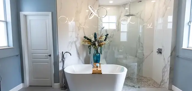 Master bathroom with a freestanding tub, marble-look slab walls and a frameless glass walk-in shower